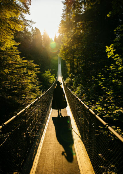 Witch in silhouette walk across the suspension bridge during Canyon Frights event at Capilano Suspension Bridge Park