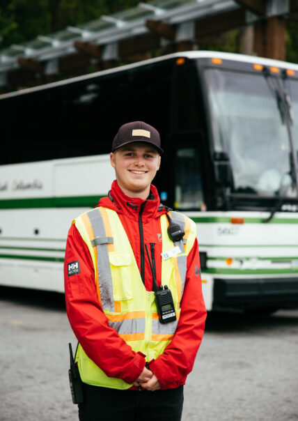 shuttle team member standing at the free shuttle at capilano suspension bridge park