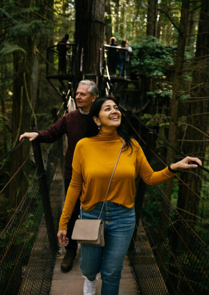 two adults enjoying treetops adventure canopy walk at capilano suspension bridge park