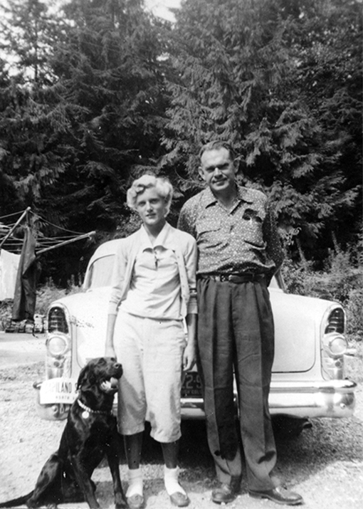 A historical black and white photo captures current owner Nancy Stibbard as a young girl standing with her father Rae Mitchell, reflecting the family legacy and continuity of stewardship at Capilano Suspension Bridge Park.