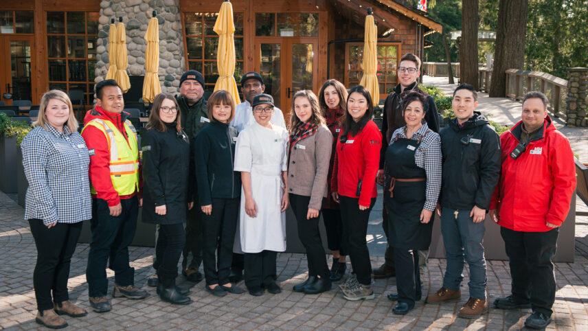 A group of team members standing in front of the Cliff House Restaurant at Capilano Suspension Bridge Park